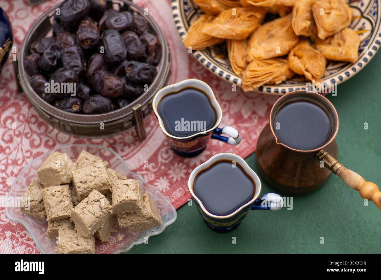 Asiatische Süßigkeiten und Kaffee auf dem Tisch. Baklava, Halva, Datteln Obst zum Nachtisch. Essen und Trinken. Stockfoto