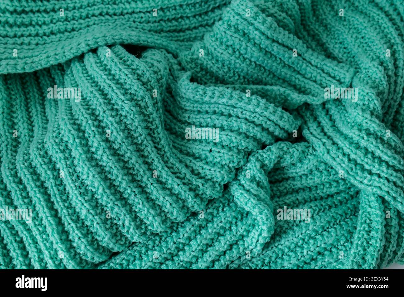 Türkisfarbener gestrickter Hintergrund mit Falten Stockfoto
