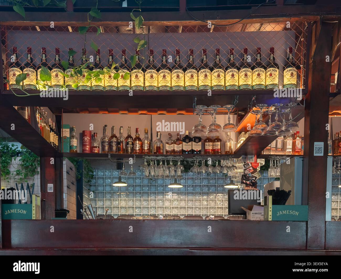 Kiew, Ukraine - 21. März 2026: Jameson Whiskey-Flaschen sind ordentlich auf einem dekorativen Regal über einer professionellen Bartheke mit hängendem Stiel angeordnet Stockfoto