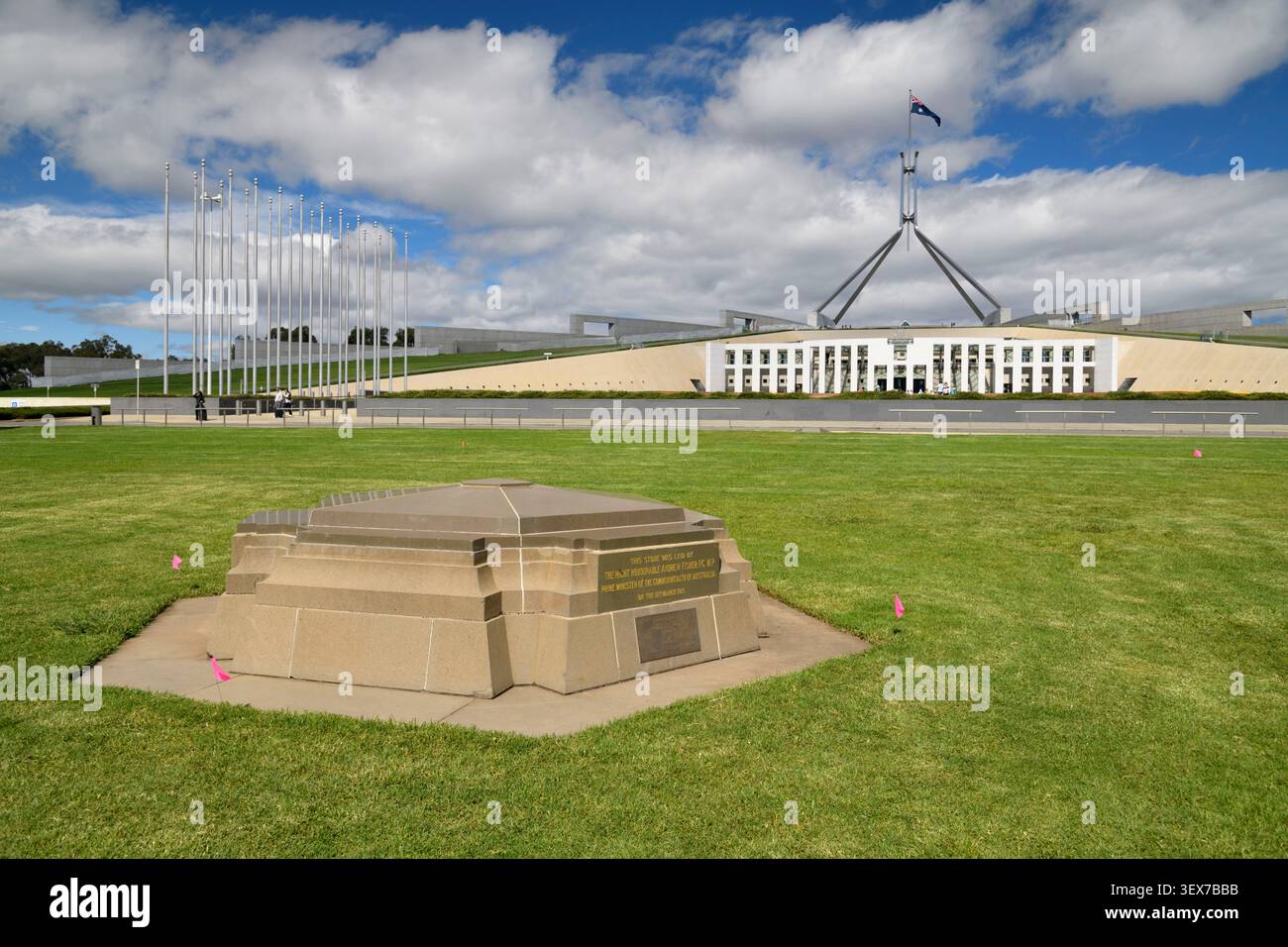 Australien, Australian Capital Territory, Canberra, Parliament House, Commitcement Column Foundation Stone, Grundstein, der am 12. März 1913 von Premierminister Andrew Fisher gelegt wurde, um den Beginn von Canberra als Bundeshauptstadt zu markieren, mit dem Parlamentsgebäude im Hintergrund Stockfoto