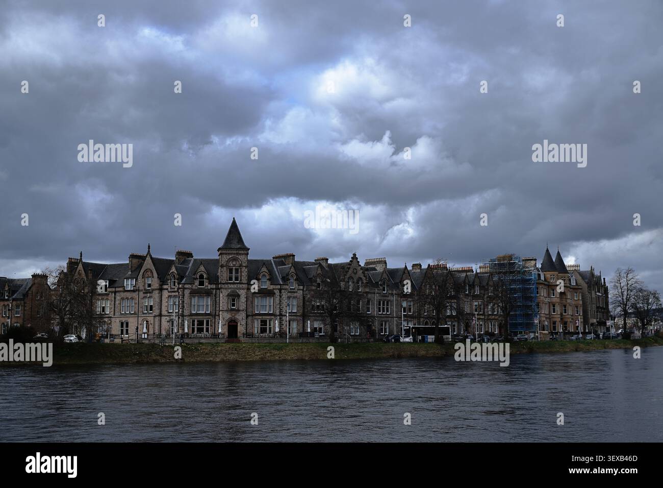 Inverness City in den schottischen Highlands, Schottland, verfügt über Gebäude am Fluss, dunkle Wolken und Wasser im Vordergrund mit der Skyline der Stadt im Rahmen. Stockfoto