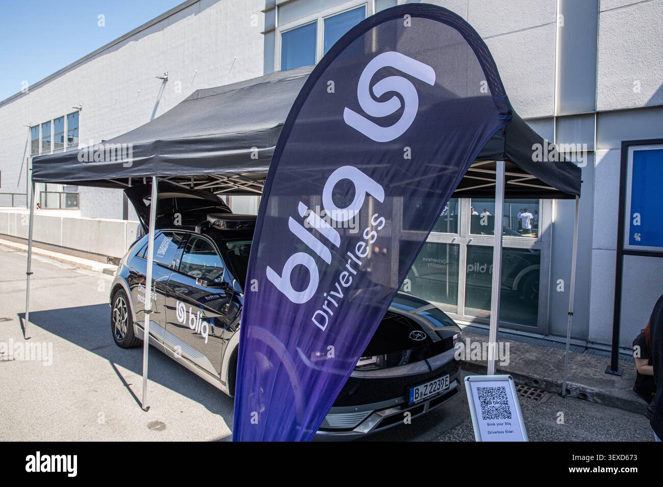 Berlin, Deutschland. 30. Juni 2026. Neben einem fahrerlosen Mobilitätsfahrzeug steht am Dienstag, den 30. Juni 2026 auf der Messe Berlin vor der GITEX AI Europe eine Bliq-Flagge. Das Unternehmen präsentierte autonome Fahrzeugtechnik während der internationalen Technologie- und Startup-Veranstaltung. (Foto: Michael Kuenne/PRESSCOV/SIPA USA) Credit: SIPA USA/Alamy Live News Stockfoto
