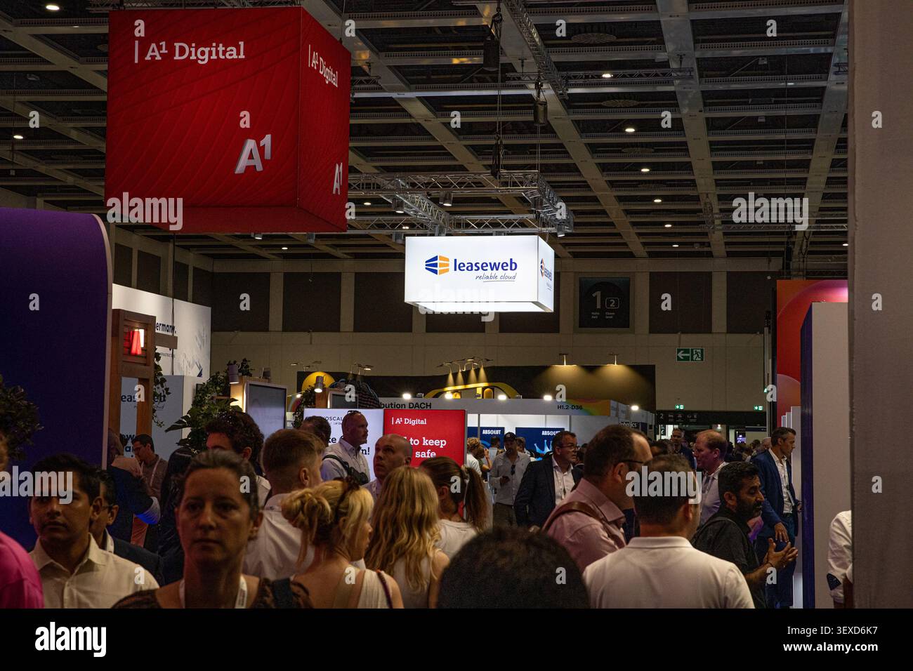Berlin, Deutschland. 30. Juni 2026. Die Besucher bewegen sich auf der GITEX AI Europe in Berlin am Dienstag, den 30. Juni 2026 unter A1 Digital- und Leaseweb-Schildern durch die Ausstellungsfläche. Bei der Technologieveranstaltung wurden Unternehmen aus den Bereichen Cloud-Computing, Telekommunikation, Cybersicherheit und künstliche Intelligenz teilgenommen. (Foto: Michael Kuenne/PRESSCOV/SIPA USA) Credit: SIPA USA/Alamy Live News Stockfoto