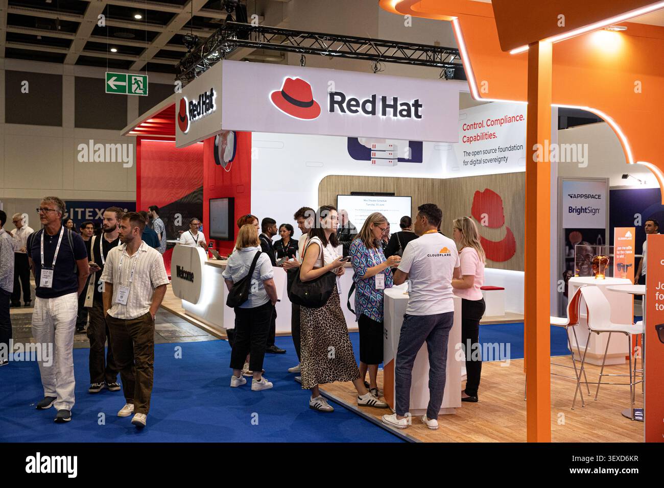 Berlin, Deutschland. 30. Juni 2026. Besucher passieren den Red hat Stand während der GITEX AI Europe am Dienstag, den 30. Juni 2026 in Berlin. Die Veranstaltung brachte globale Cloud-, Open Source- und künstliche Intelligenz-Unternehmen zusammen, während Europa seine digitale Infrastruktur und technologische Kapazität ausbauen will. (Foto: Michael Kuenne/PRESSCOV/SIPA USA) Credit: SIPA USA/Alamy Live News Stockfoto
