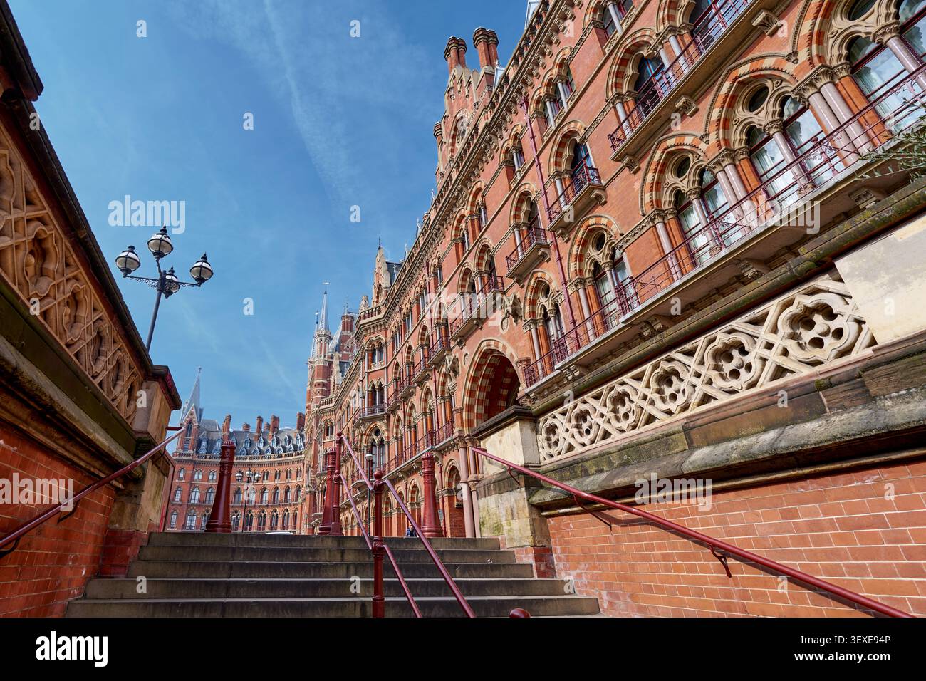 Sehr detaillierte Fassade eines kunstvollen, roten Backsteingebäudes in der viktorianischen Ära in London mit komplizierten Steinmetzwerken, Bögen und dekorativen Elementen. Stockfoto