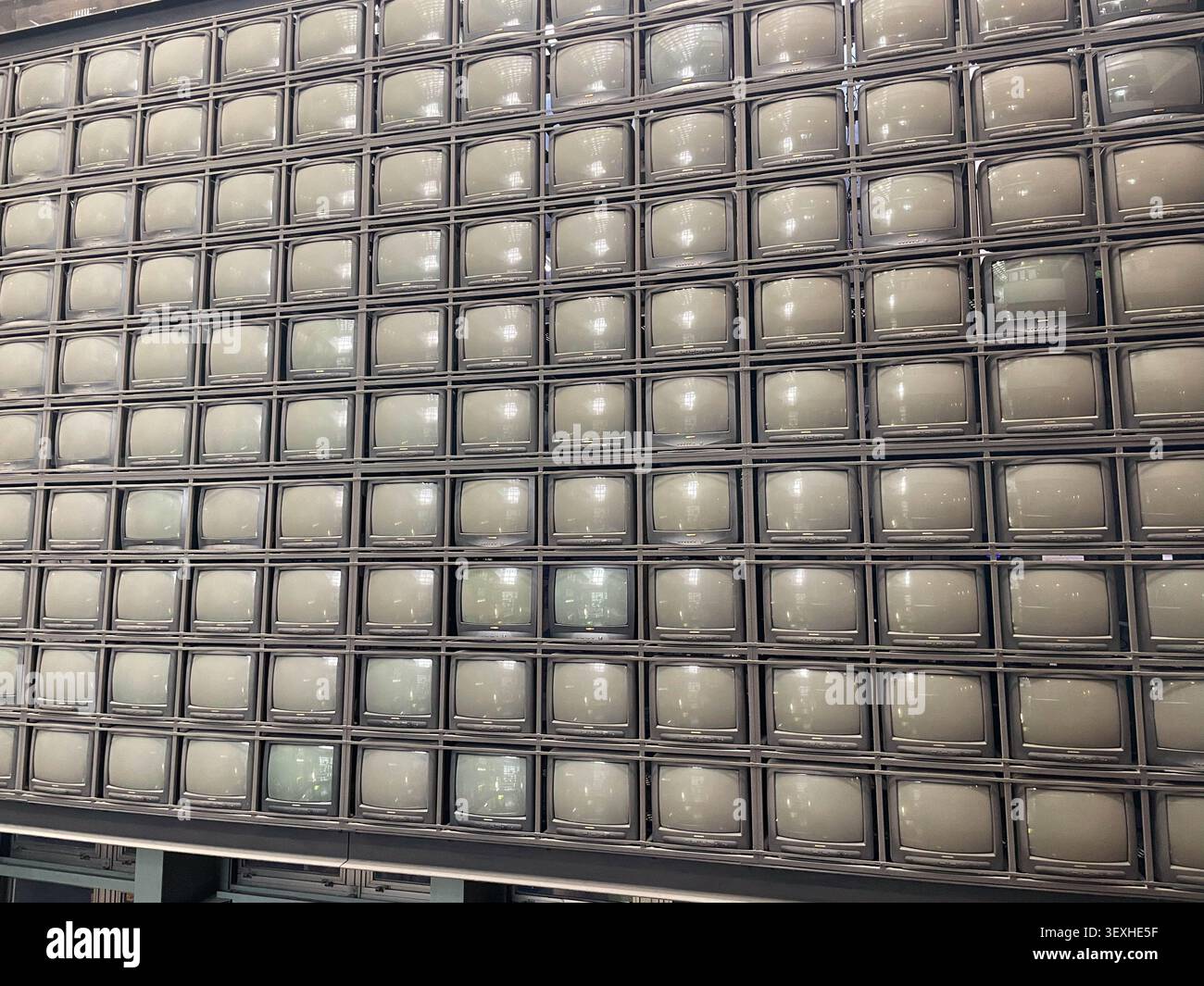 Reihen von Retro-CRT-Fernsehbildschirmen, die als Teil einer modernen Kunstinstallation eine große Medienwand bilden. Fukuoka, Japan - 31. Oktober 2025. Stockfoto