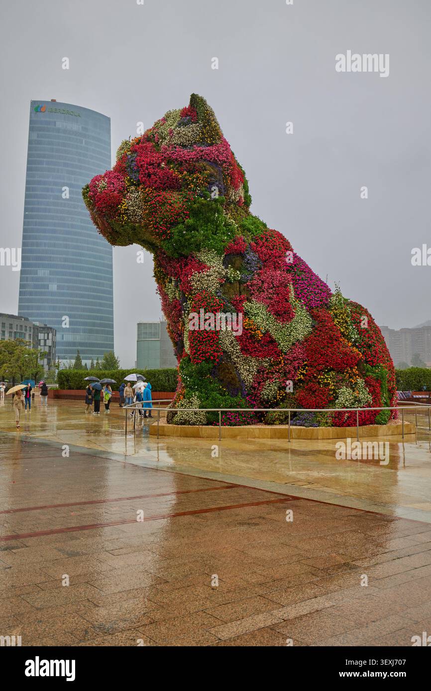 Farbenfrohe, von Jeff Koons entworfene Puppenskulptur mit Blumenmuster vor dem Guggenheim Museum. Bilbao, Spanien - 12. September 2024. Stockfoto