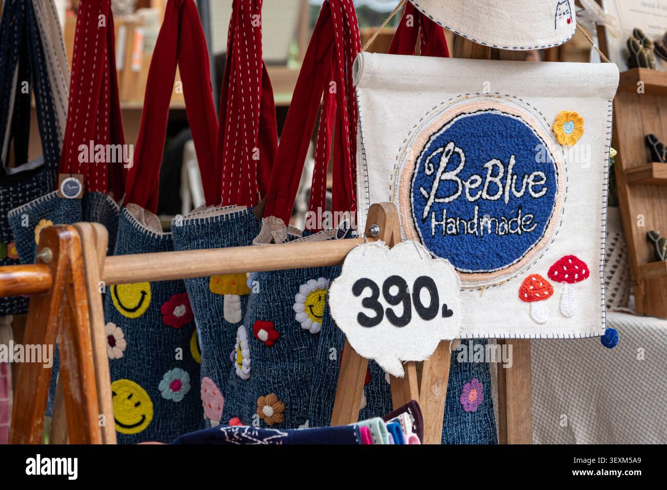 Chiang Mai, Thailand - 27. Mai 2026 : BeBlue Handmade Shopschild mit aufgesticktem Logo und Jeanstaschen mit Smiley Face Patches auf dem Jing Jai Market Stockfoto