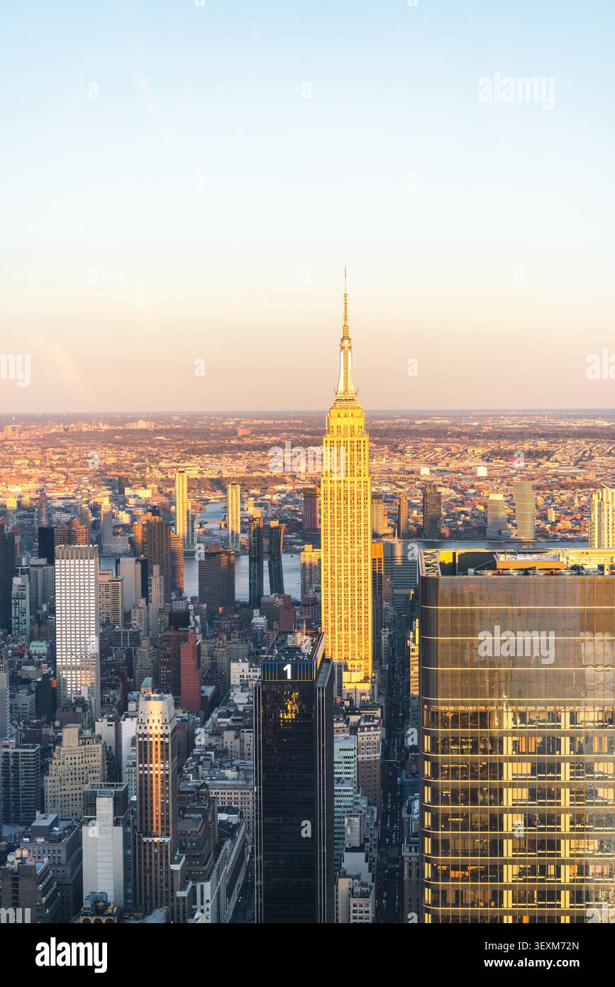 Die ikonische Skyline leuchtet im goldenen Licht eines New Yorker Sonnenuntergangs. Stockfoto