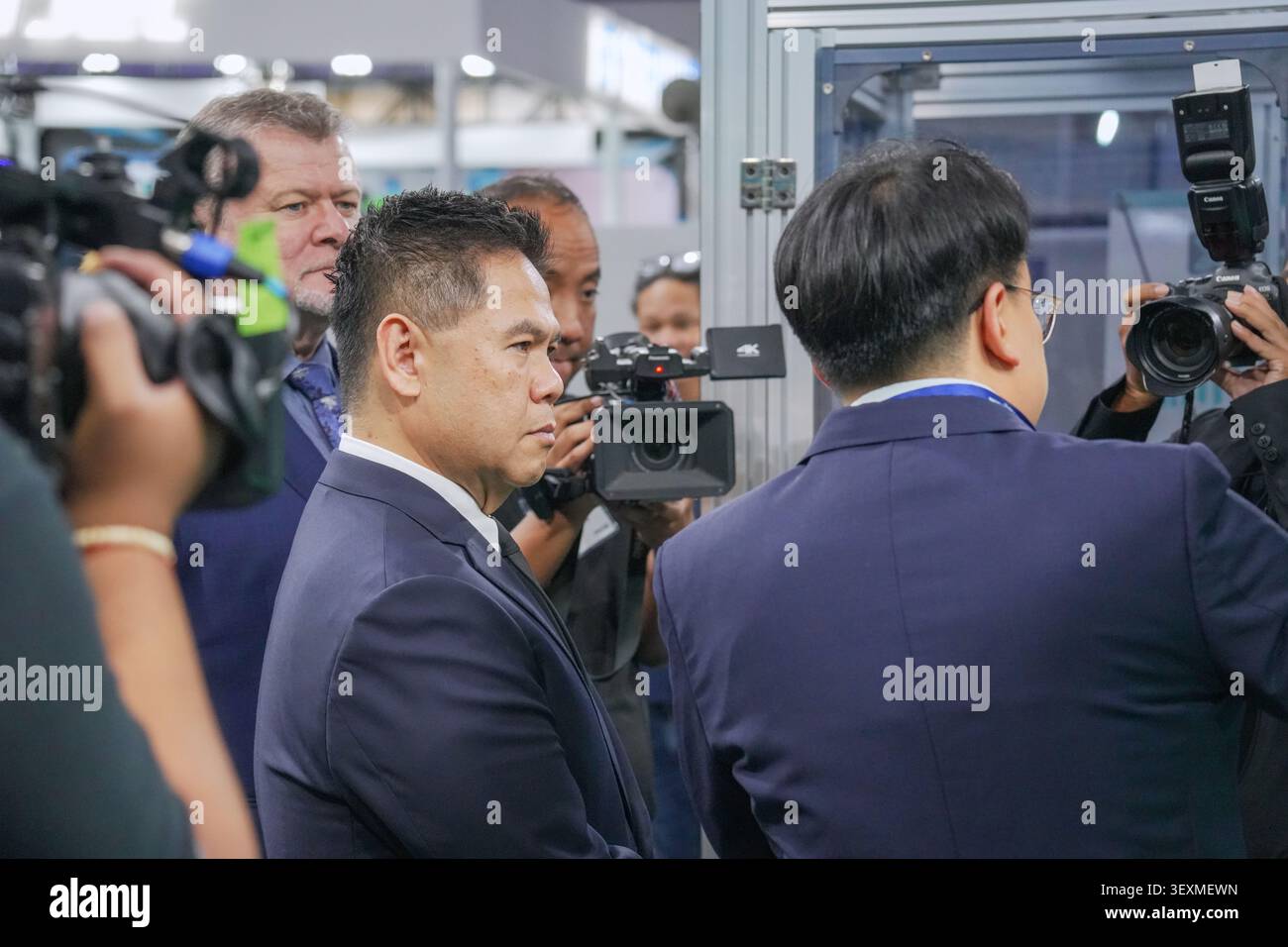 Bangkok, Thailand - 17. Juni 2026: Geschäftsmann umgeben von Pressefotografen und Videofilmen auf der Manufacturing Expo in Bangkok Stockfoto