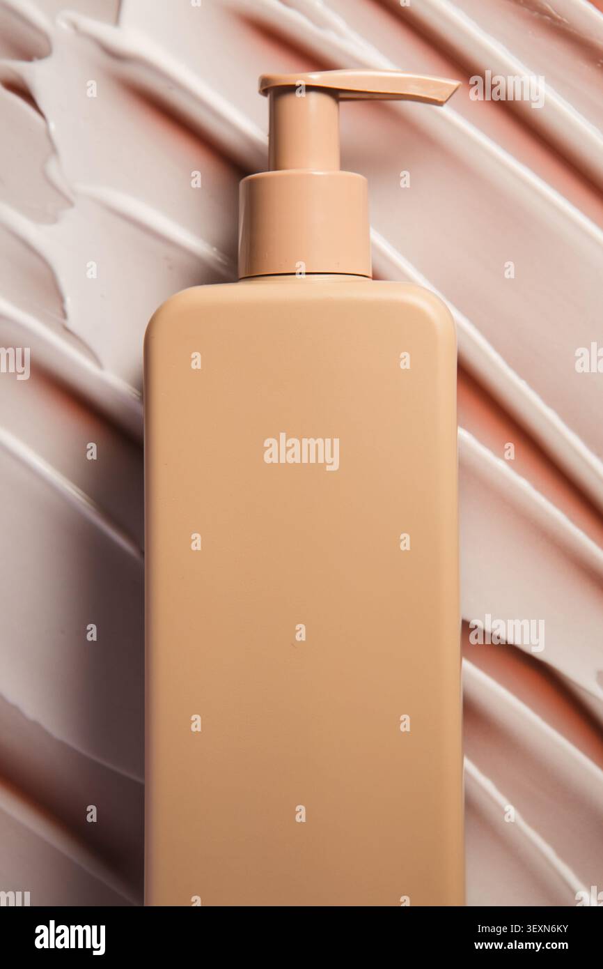 Zentrierte Lotionsflasche auf weicher Creme Stockfoto
