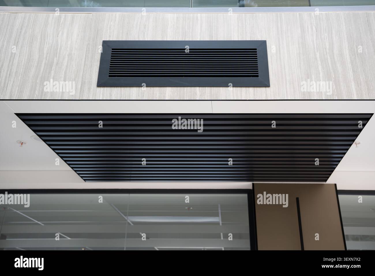 Moderne Bürofassade mit klaren architektonischen Linien und zeitgenössischen Deckendetails in einem Firmengebäude. Unternehmensarchitektur und modernes DE Stockfoto