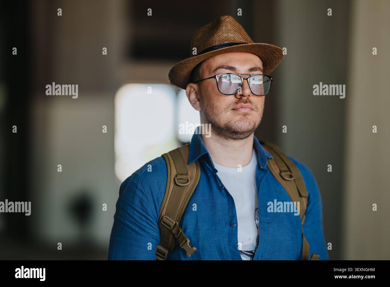 Alleintourist mit Hut und Rucksack, der in Stadtreiseporträt nach vorne blickt Stockfoto