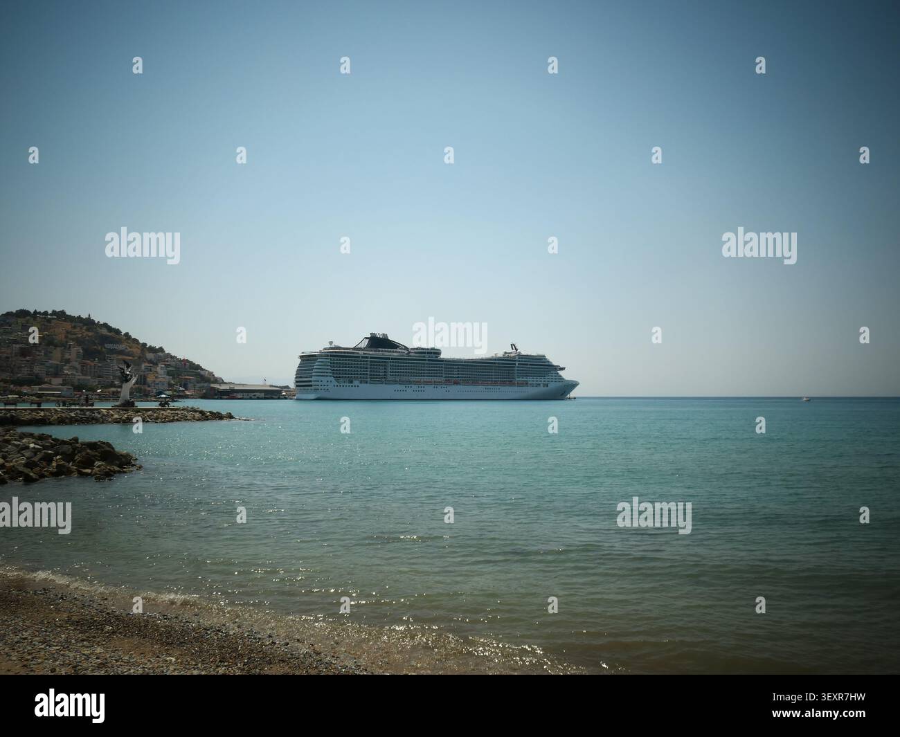 Großes weißes Kreuzfahrtschiff vor Anker an einer felsigen Küste Stockfoto