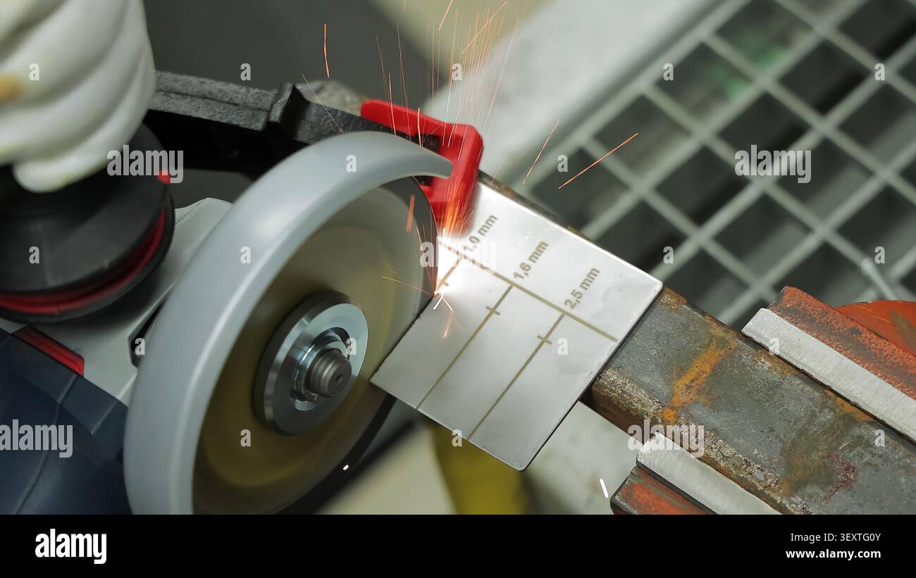 Winkelschleifer Schneiden Markierter Metallmesser. Der Winkelschleifer schneidet ein markiertes Metalldickenmessgerät, das auf einer rostigen Werkbank befestigt ist, und wirft Funken. Stockfoto