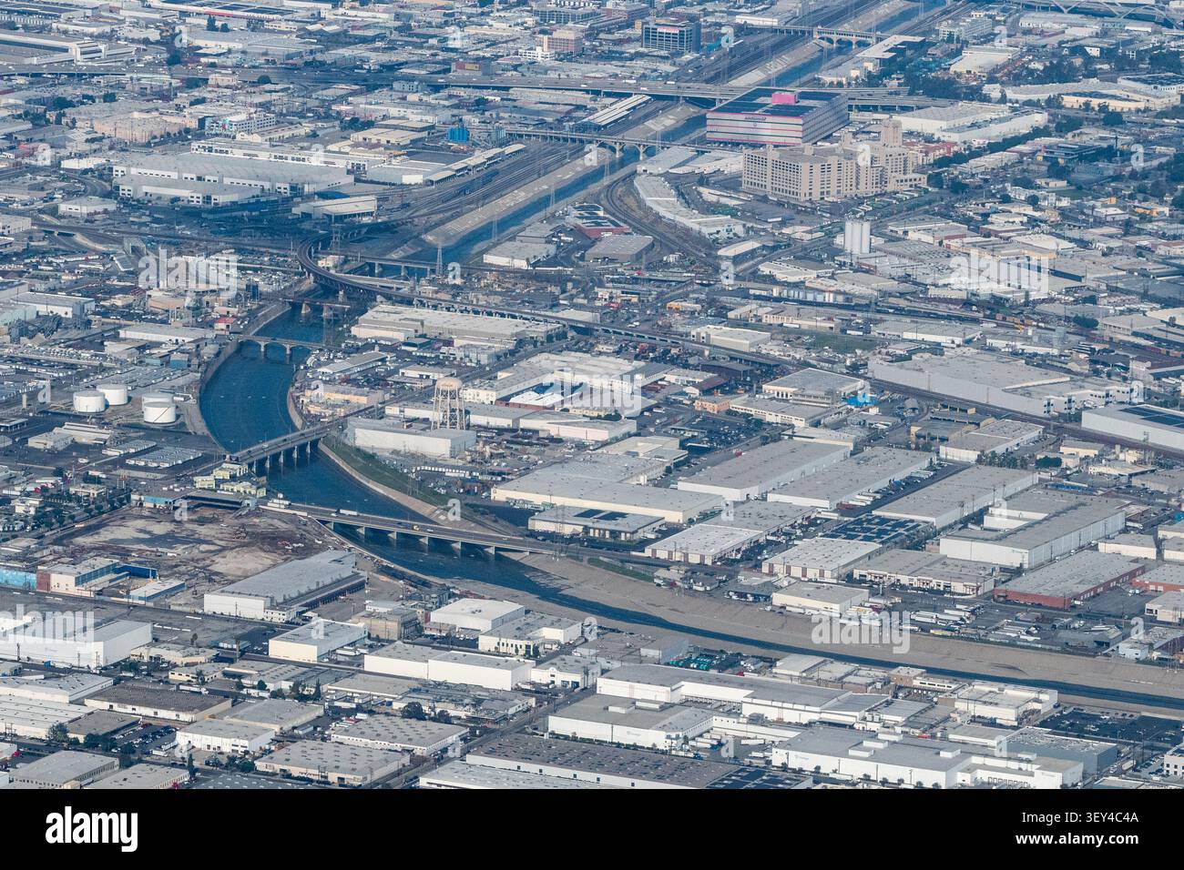 Blick aus der Vogelperspektive auf den Los Angeles River, der sich durch die Industriestadt Vernon, Kalifornien, schlängelt, mit Eisenbahnlinien, Brücken und Lagerhäusern Stockfoto