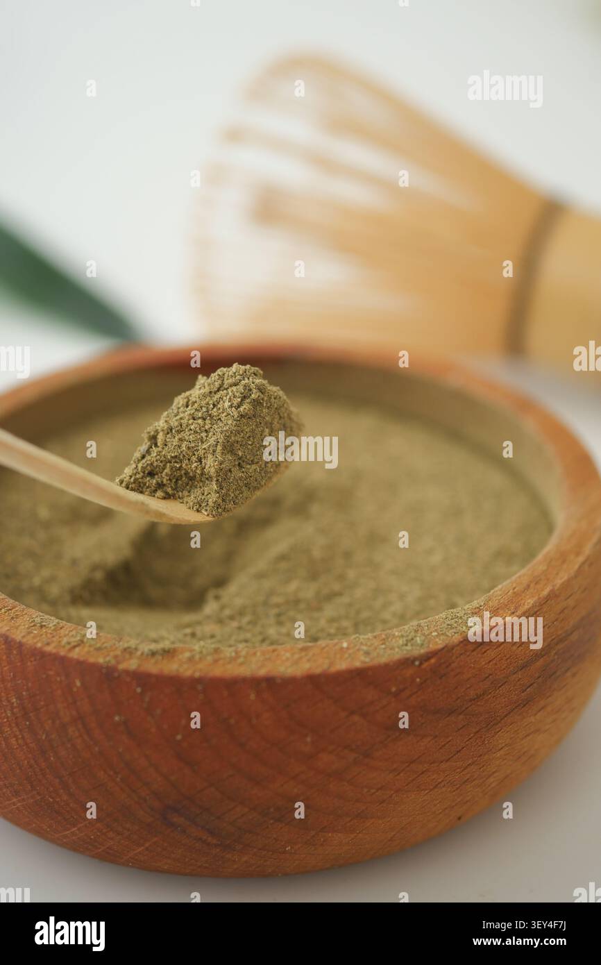 Matcha-Pulver in einer Holzschale mit Bambusquirl Stockfoto