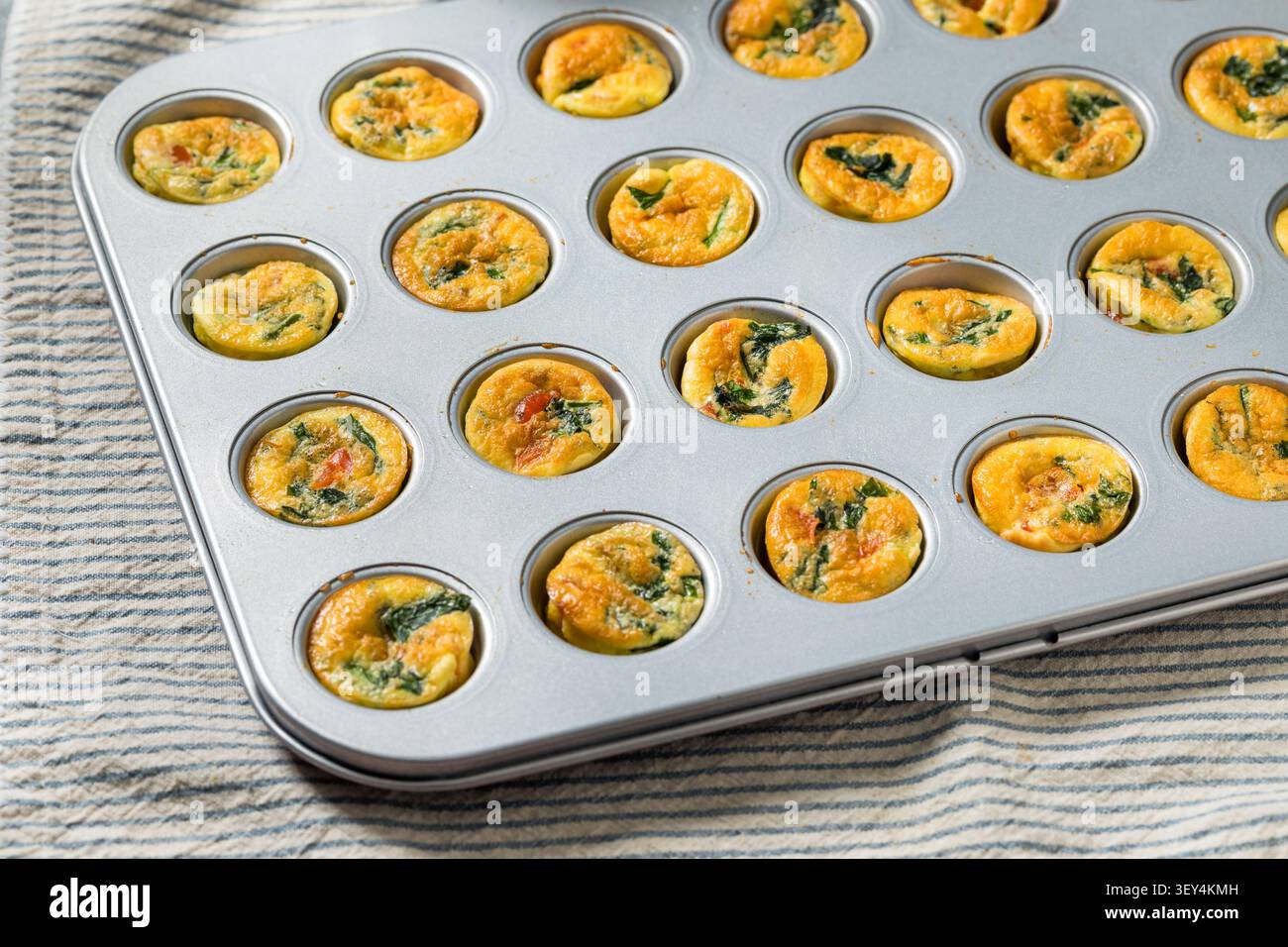 Hausgemachte gesunde Ei-Biss-Muffins mit Spinat und Pfeffer Stockfoto