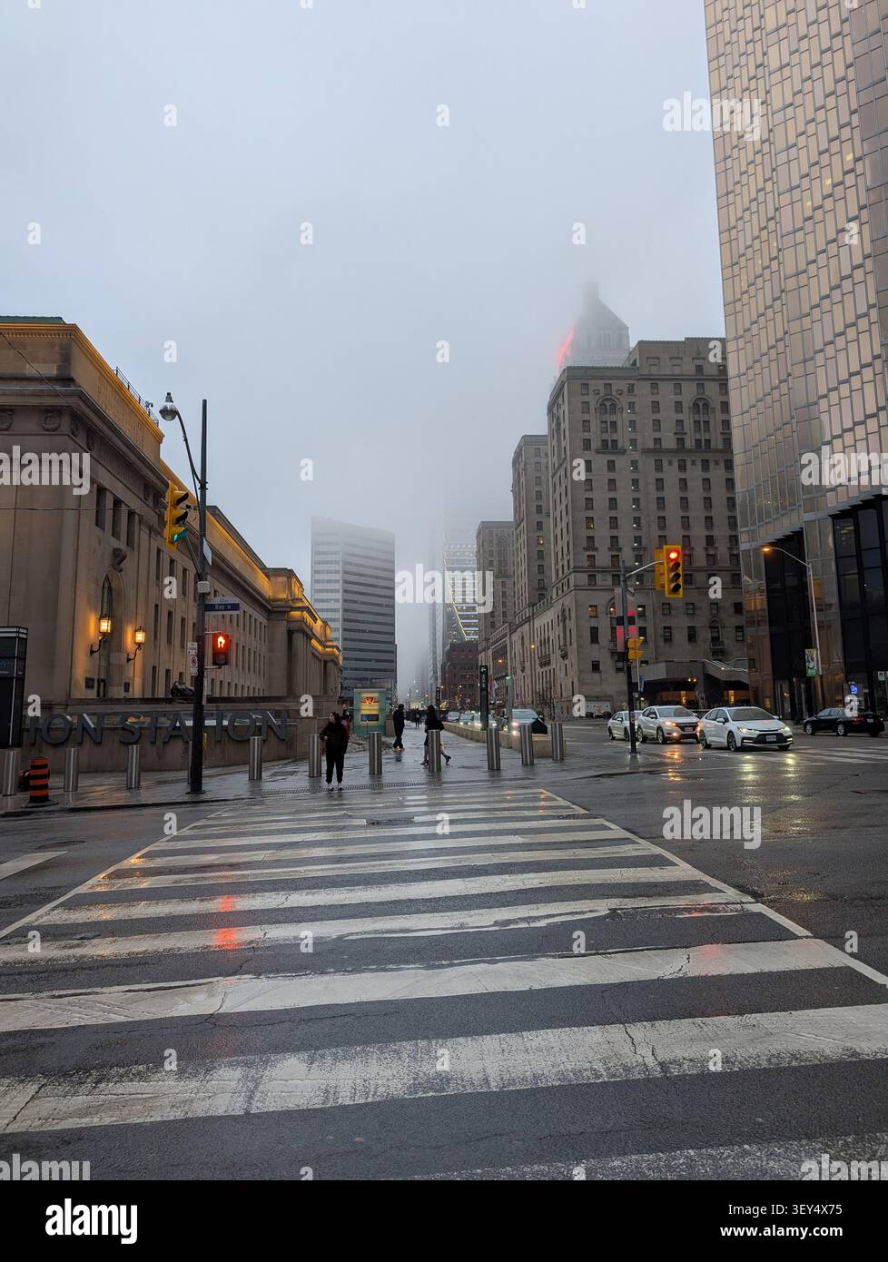 Toronto Innenstadt - Morgennebel in der Stadt - Wolken verdecken Wolkenkratzer, nasse Straßen, kalte graue Töne - Toronto, Ontario, Kanada Stockfoto