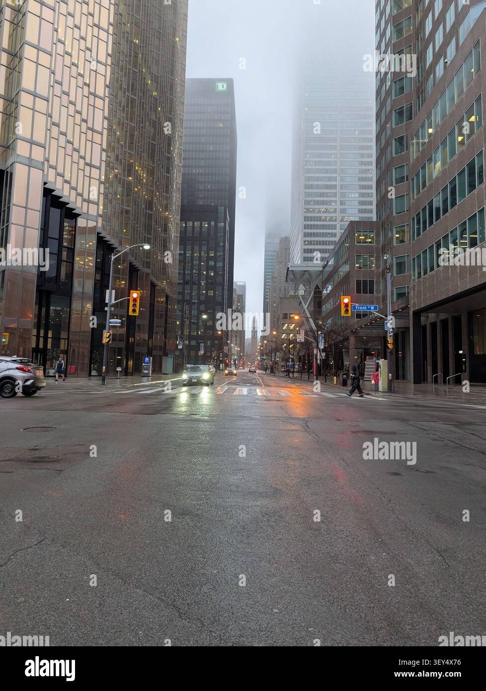 Toronto Innenstadt - Morgennebel in der Stadt - Wolken verdecken Wolkenkratzer, nasse Straßen, kalte graue Töne - Toronto, Ontario, Kanada - Smartphone-aufgenommenes Stockfoto