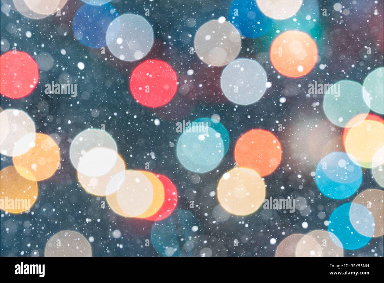 Horizontaler festlicher Hintergrund mit mehrfarbigen Bokeh-Lichtern in Rot, Gelb, Grün, Orange, Blau, und weiß vor dunkelgrünem Hintergrund. Sturz Stockfoto