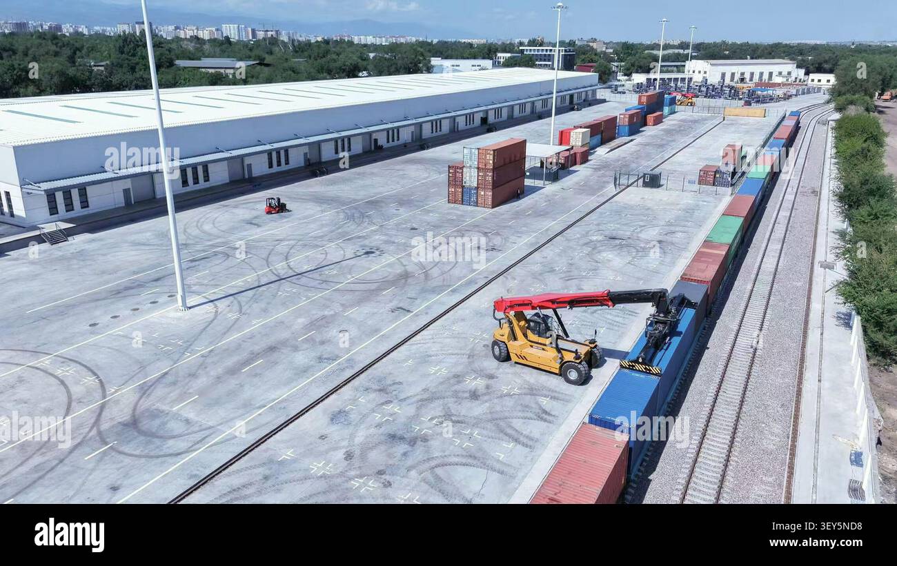 (260702) -- ALMATY, 2. Juli 2026 (Xinhua) -- ein am 25. Juni 2026 aufgenommenes Luftdrohnenfoto zeigt einen Mitarbeiter, der einen Kran für Container des China-Europa-Güterzuges im kasachischen Landhafen für Xi'an in Almaty, Kasachstan, betreibt. Im November 2013 fuhr der erste China-Europa-Güterzug von Xi'an nach Almaty in Kasachstan, was die beiden Städte zu wichtigen Transitdrehkreuzen auf der asiatisch-europäischen Transportstrecke machte. Seit dem ersten China-Zentralasien-Gipfel im Jahr 2023 haben China und Kasachstan ihre Kooperationsformen durch die Einführung moderner Logis neu gestaltet Stockfoto