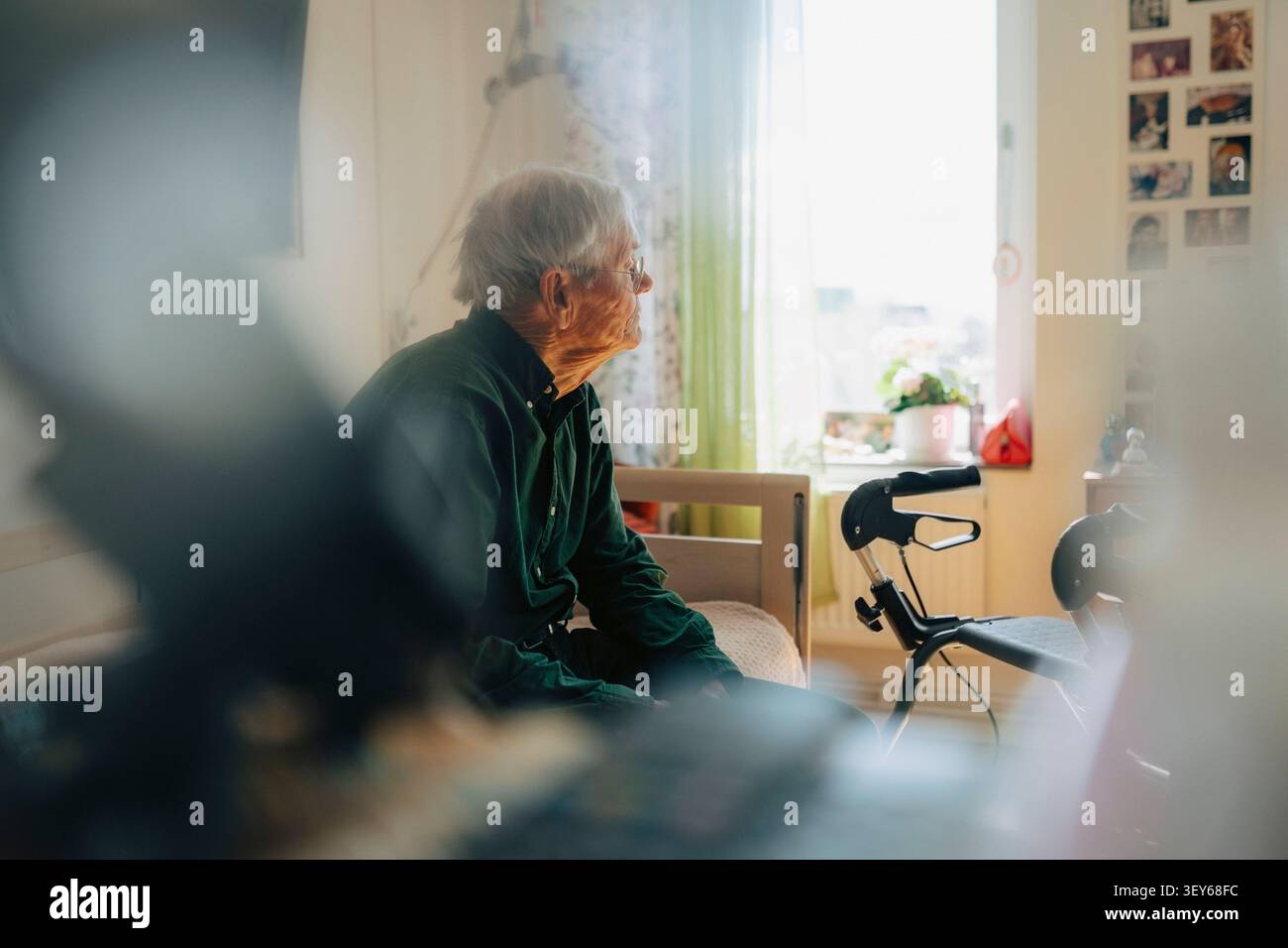 Einsamer älterer Mann, der nachdenkt, während er im Altersheim auf dem Bett sitzt Stockfoto