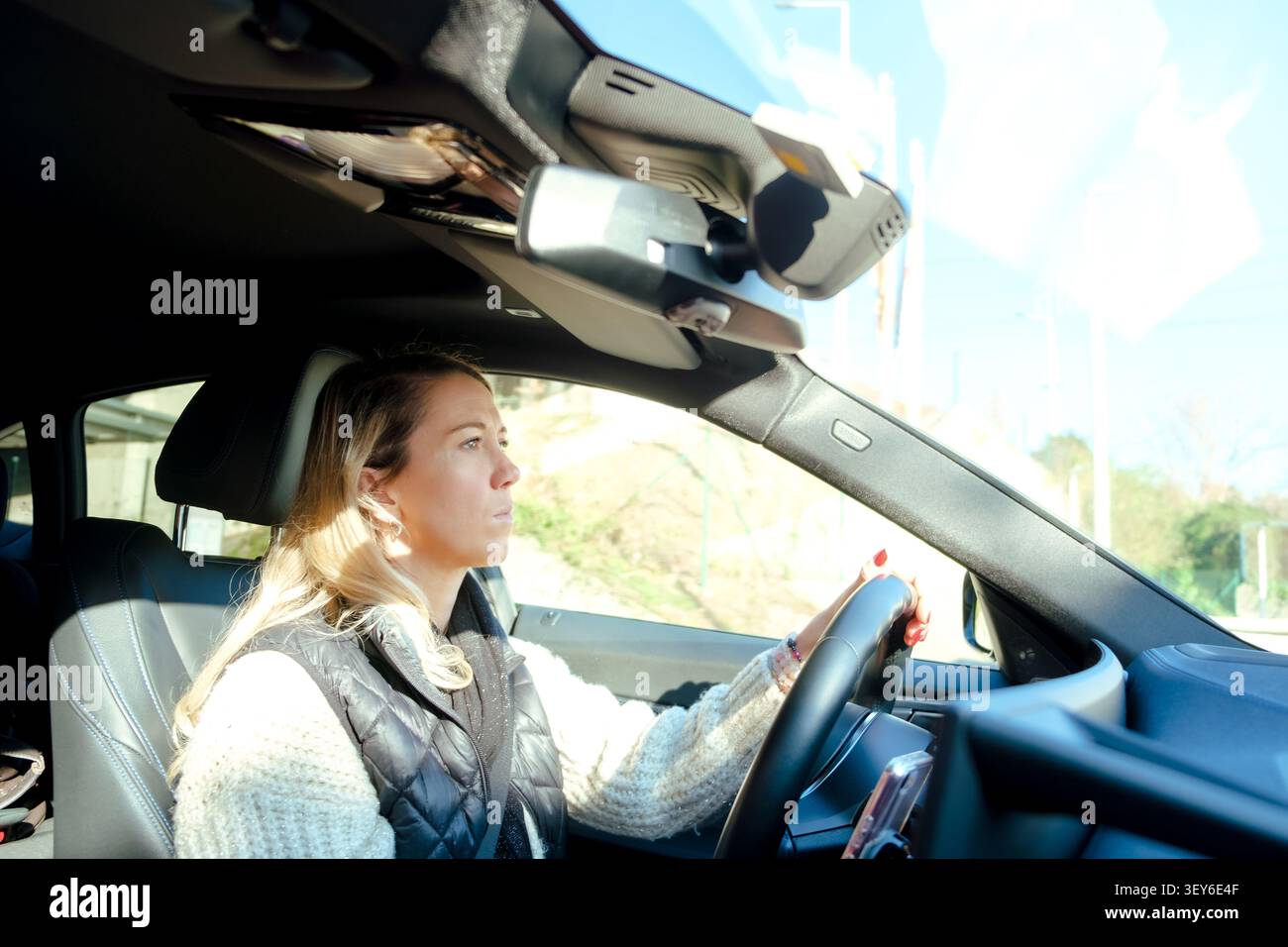 Frau, die ein Auto fährt und geradeaus auf die Straße blickt Stockfoto