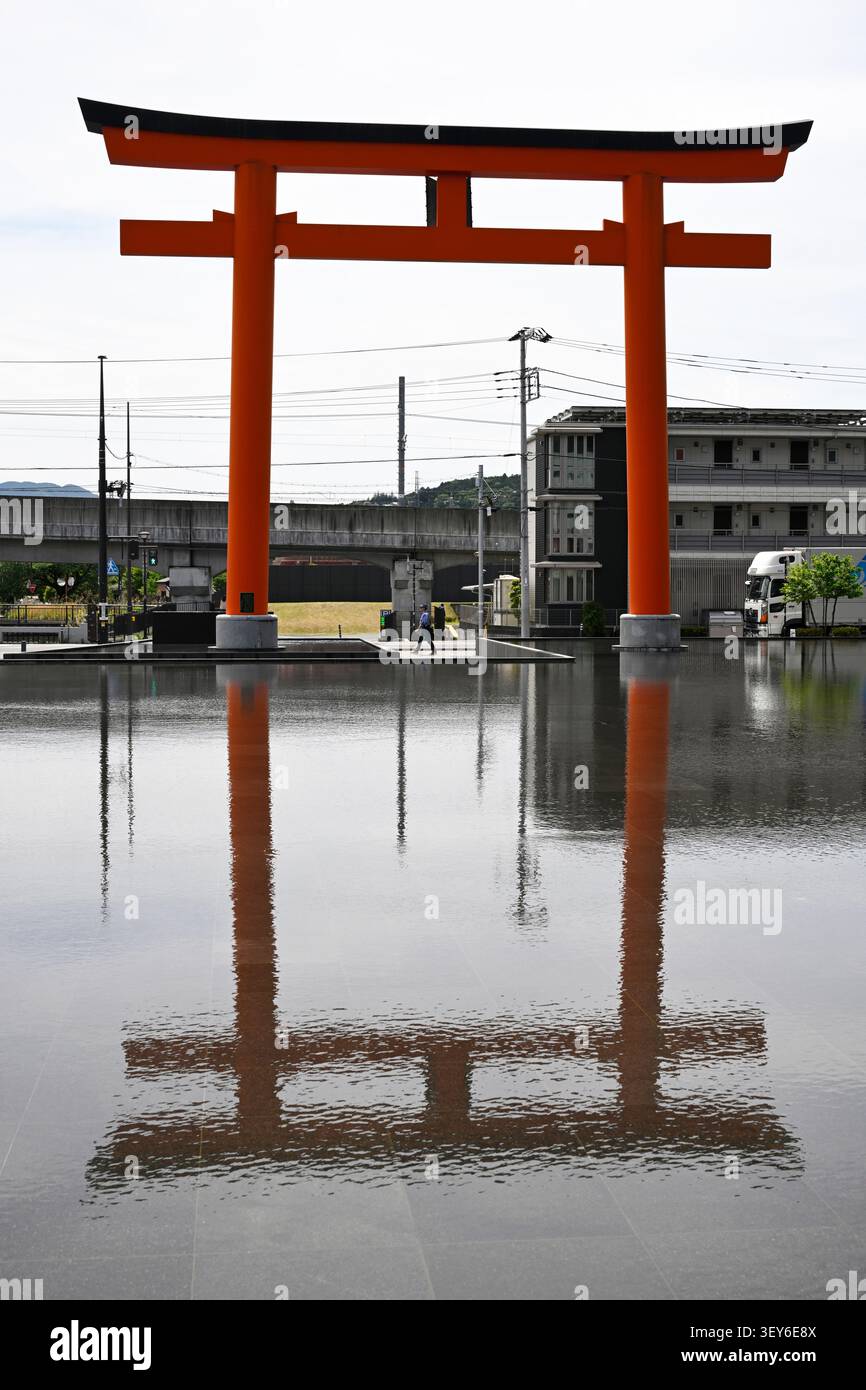 Das riesige, kühne Torii-Tor am Eingang zum Mt. Das Fuji World Heritage Center spiegelt sich in einem flachen Wasserbecken in Fujinomiya, Shizuoka Pre, wider Stockfoto