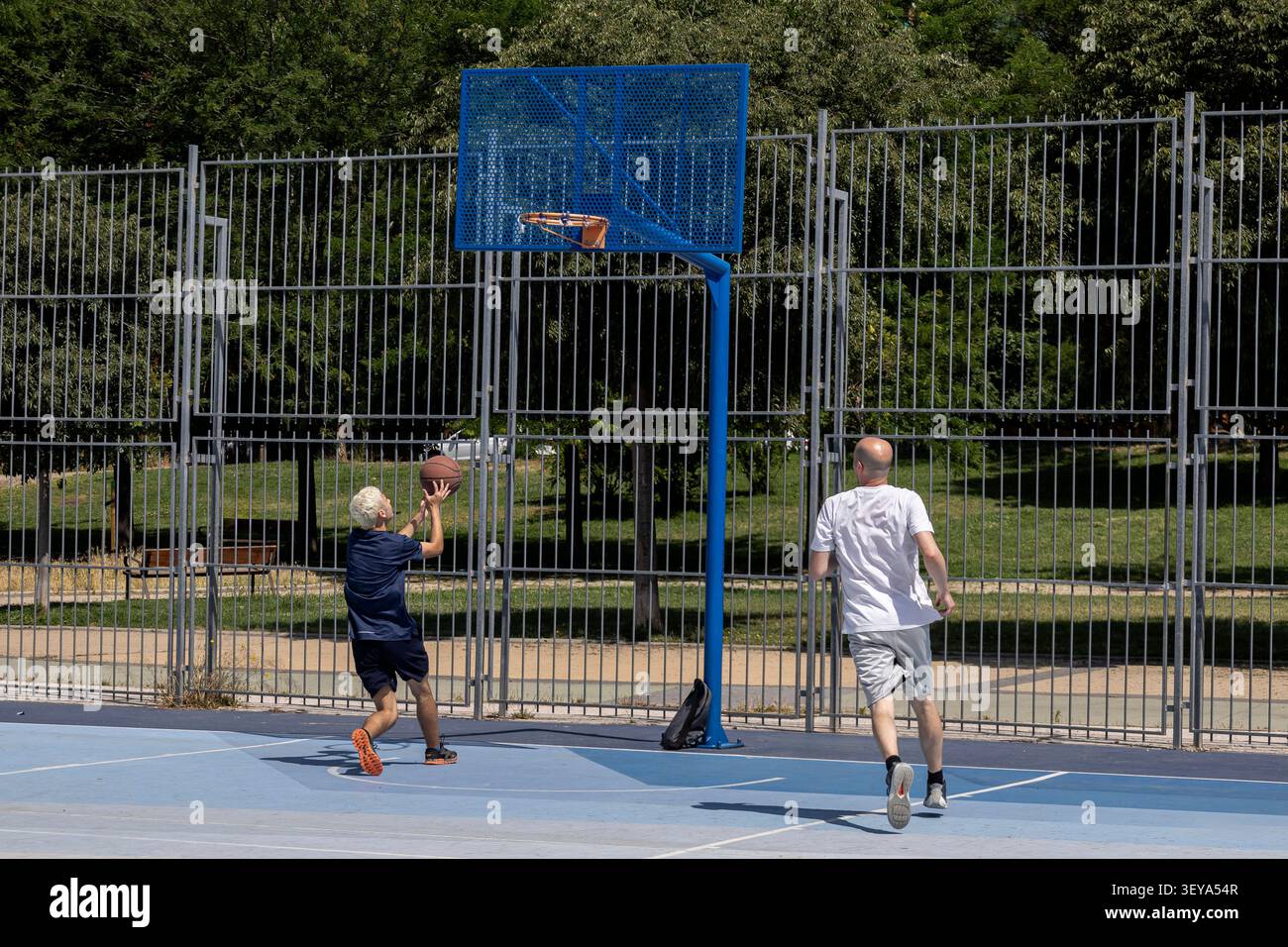 Männer spielen Basketball auf einem Platz im Freien Stockfoto