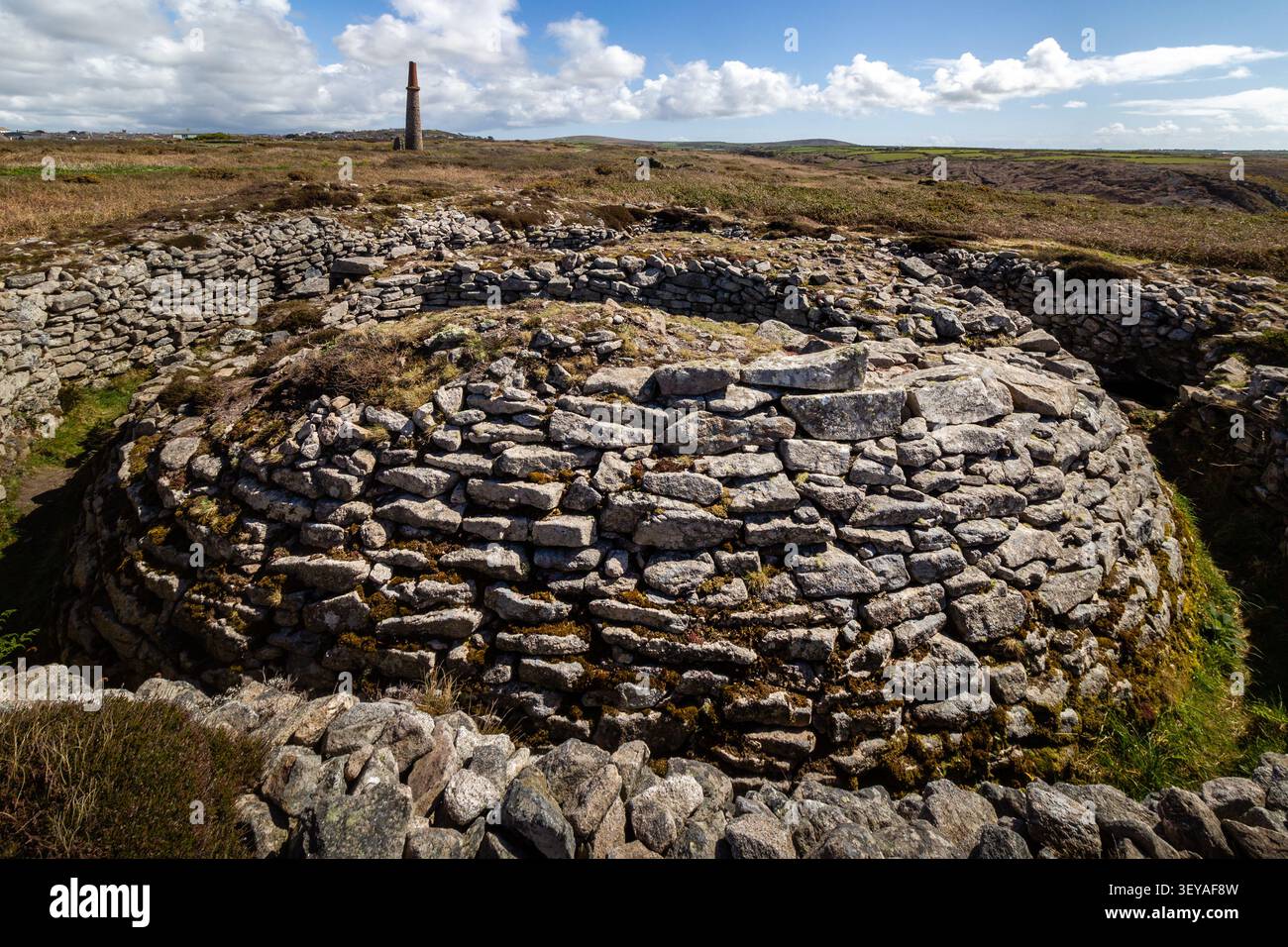 Weitwinkelaufnahme, die die gesamte Hügelstruktur von Ballowall Barrow mit Blick auf die riesige blaue Atlantikküste zeigt Stockfoto