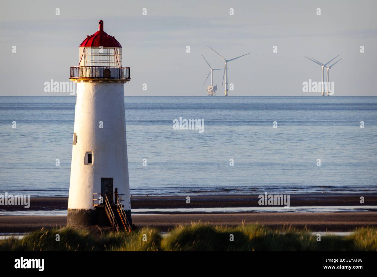 Der historische Punkt des Ayr Lighthouse, der an den Sandstränden des Talacre Beach steht, mit Offshore-Windturbinen, die am fernen Meereshorizont sichtbar sind Stockfoto