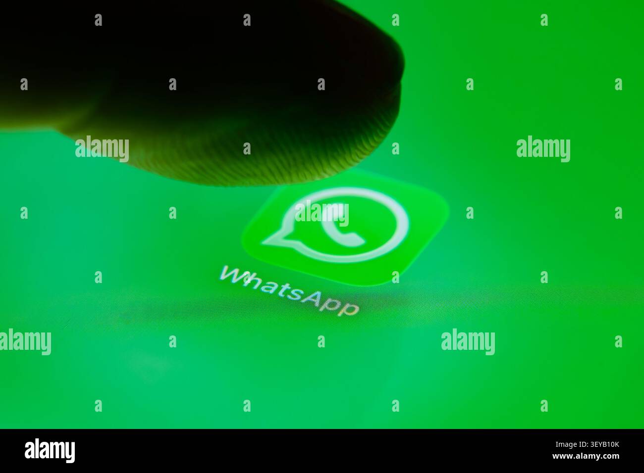 Paris, Frankreich – 2. Juli 2026: Ein Finger, der mit dem WhatsApp-Logo auf einem hellgrünen Touchscreen interagiert. Stockfoto
