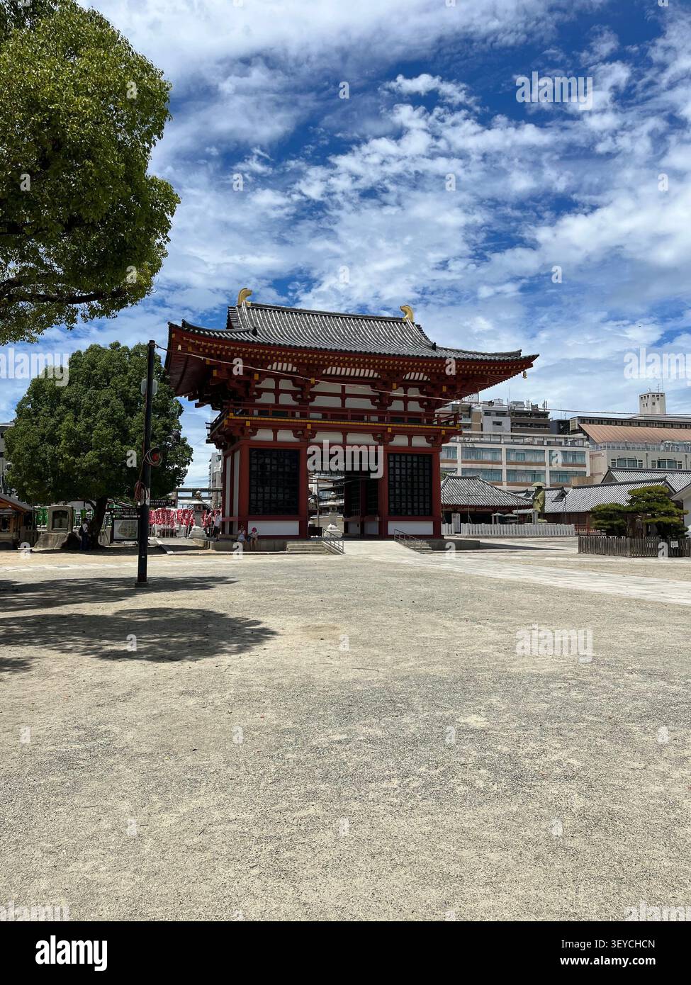 Senso-JI buddhistisches Tempeltor in Asakusa, Tokio, Japan. Traditionelle rote Architektur im Kontrast zu modernen Stadtgebäuden unter wolkenblauem Himmel. - Smartphone-aufgenommenes Stockfoto