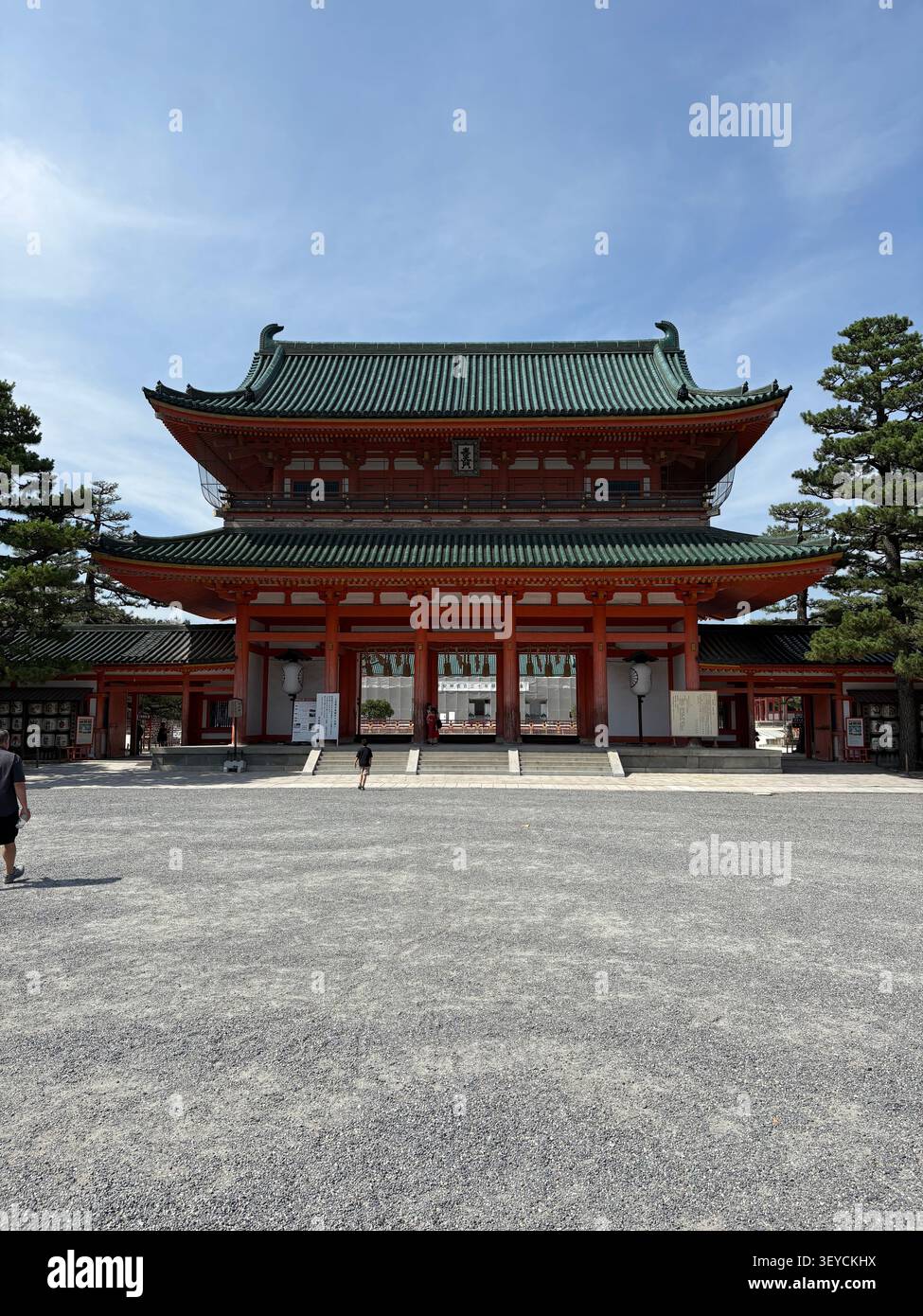 4. August 2025, Kyoto, Japan - traditionelle, unveränderte und begrünte Haupthalle des Heian Jingu-Schreins mit Schotterhof unter blauem Himmel. - Smartphone-aufgenommenes Stockfoto