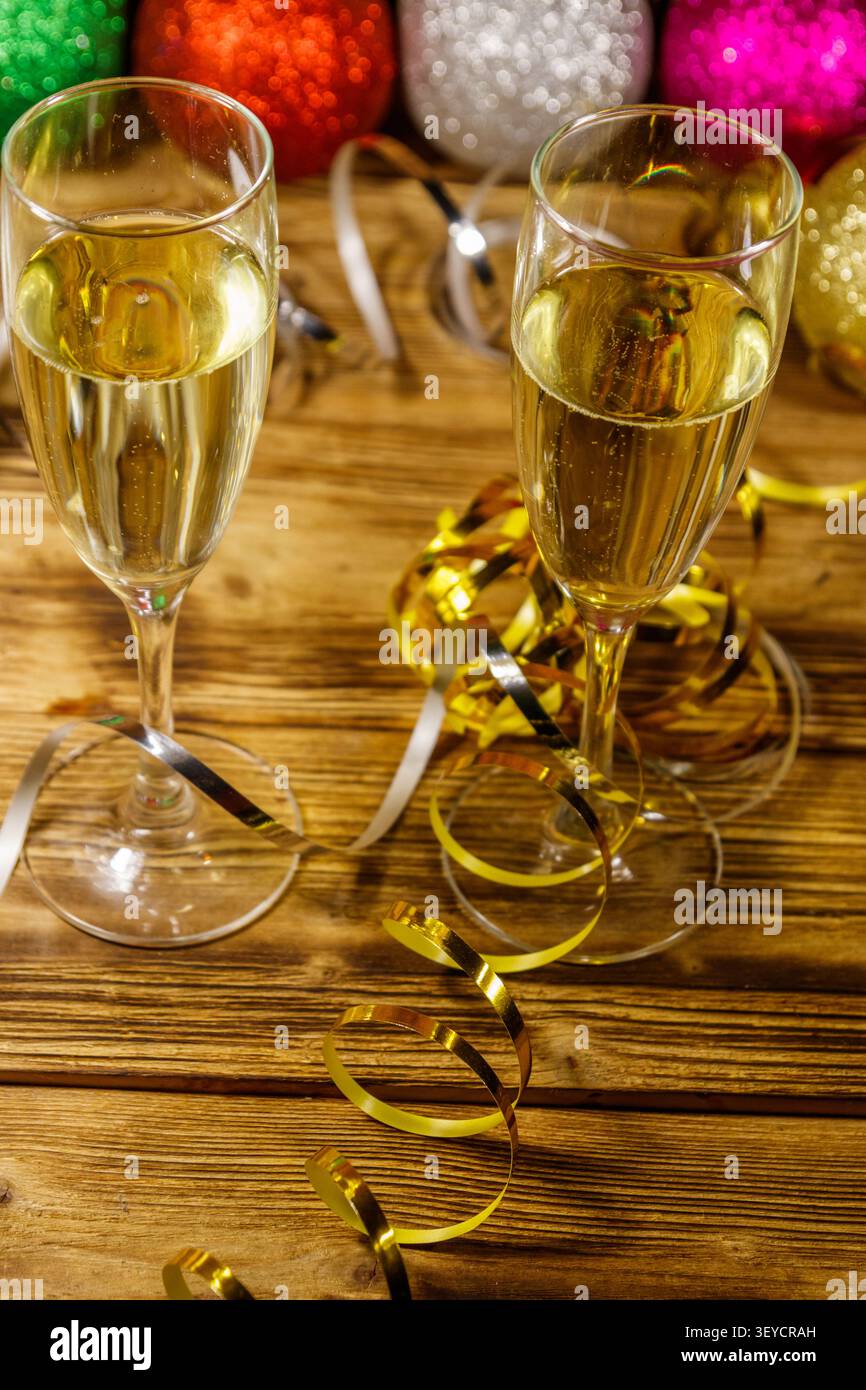 Zwei Gläser Champagner und festliche Weihnachtsdekoration auf Holztisch. Weihnachten und Neujahrsfeier Stockfoto