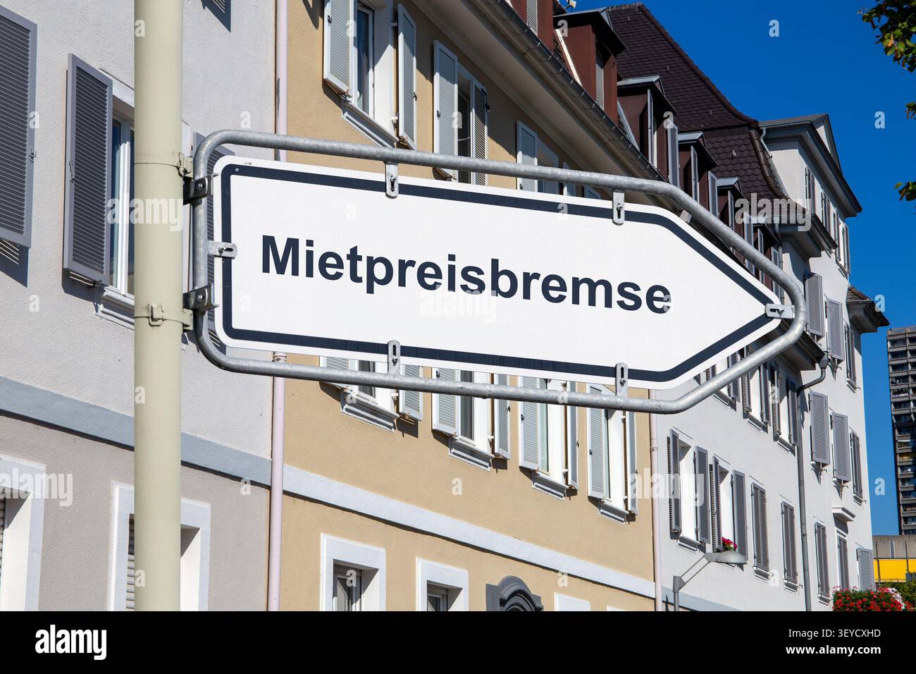 (Fotomontage) Schild mit MIETPREISBREMSE vor älteren Wohnungen in der Stadt Stockfoto