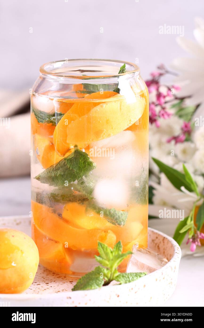 Erfrischender Pfirsicheistee mit Eis und Minze Stockfoto