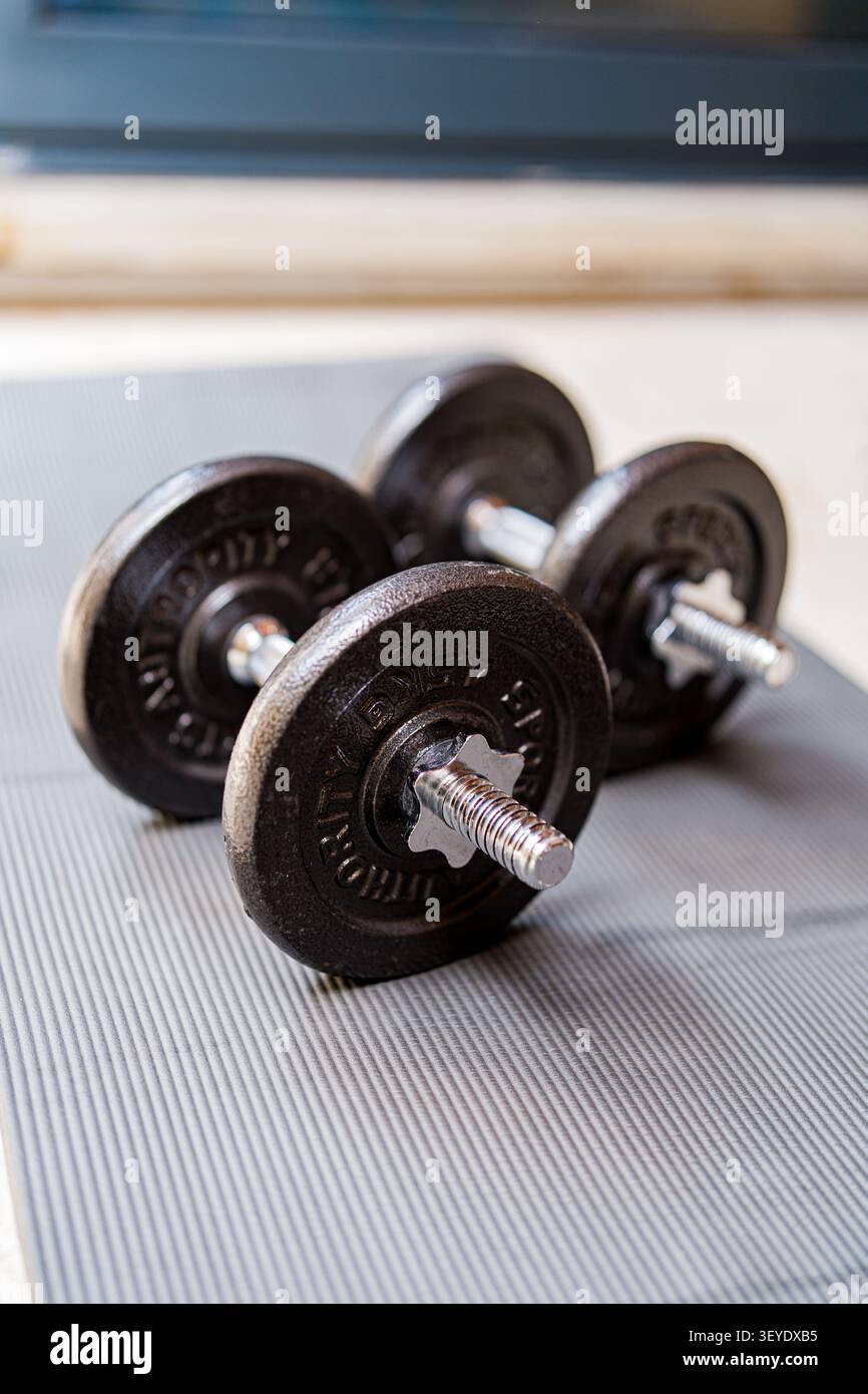 Verstellbare Hanteln für Krafttraining auf dem Fitnessstudio-Boden Stockfoto