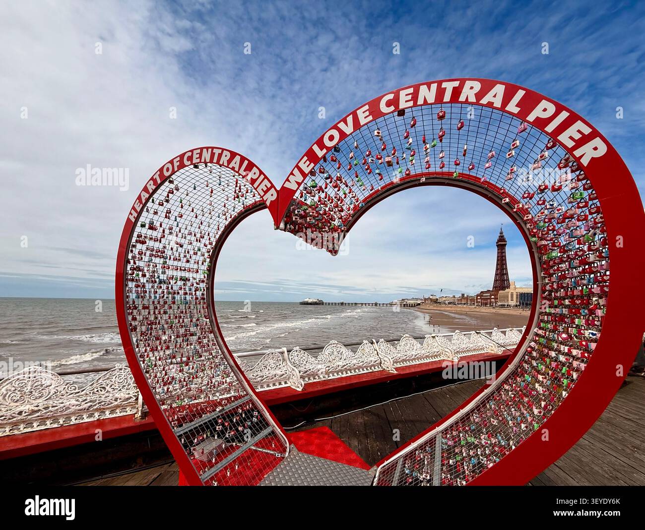 Blackpool Tower und Seepromenade eingerahmt von einer Herzstruktur mit Vorhängeschlössern auf dem Central Pier. Stockfoto