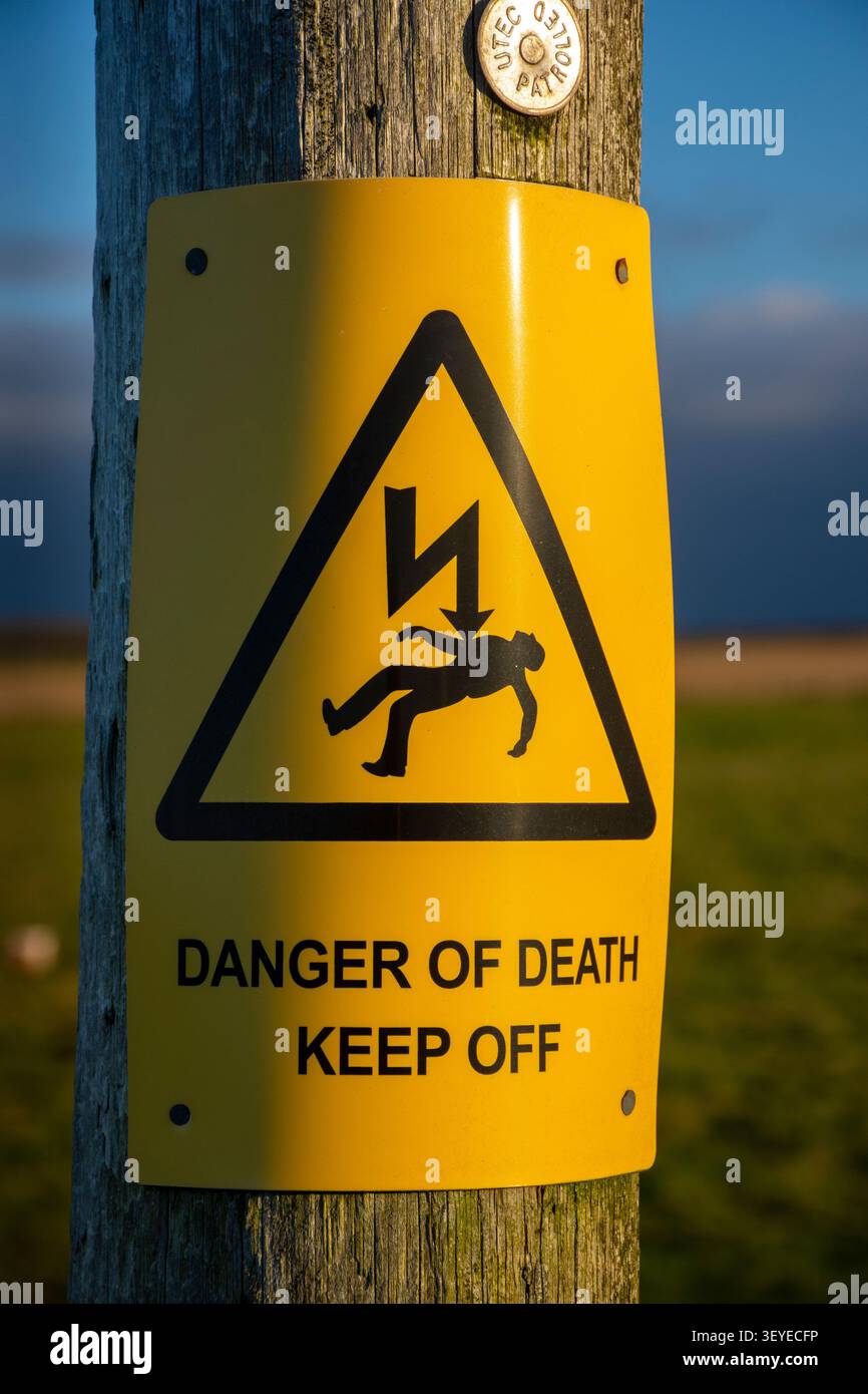 Warnschild für Todesgefahr an einem Stromposten in der Nähe des Dorfes Mey, Caithness, Schottland, Großbritannien. Stockfoto