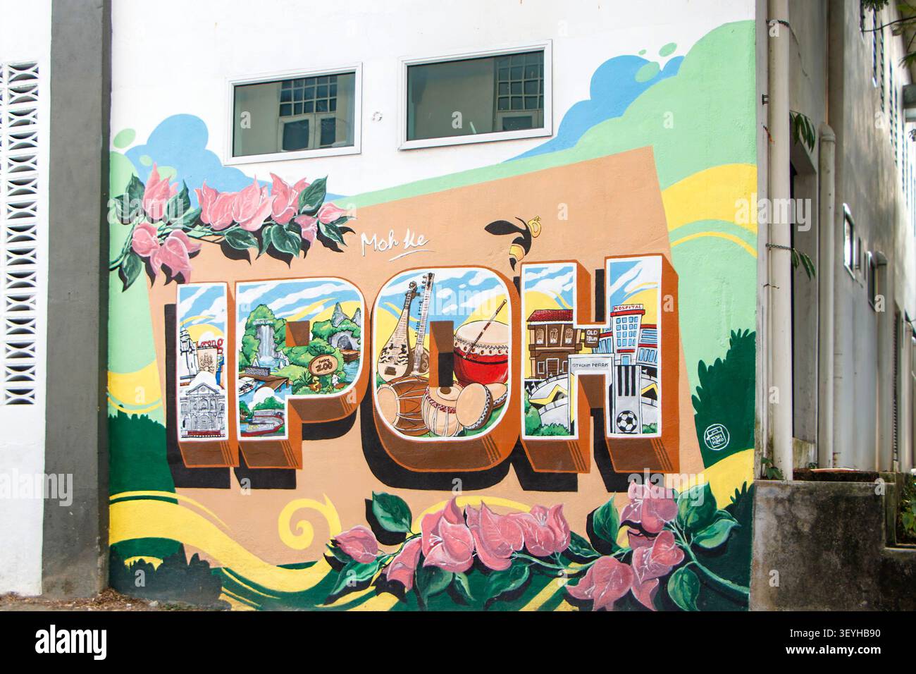 Tourist mit Rucksack, der das farbenfrohe Ipoh-Wandbild an einer Gebäudewand in Ipoh, Perak, Malaysia fotografiert Stockfoto
