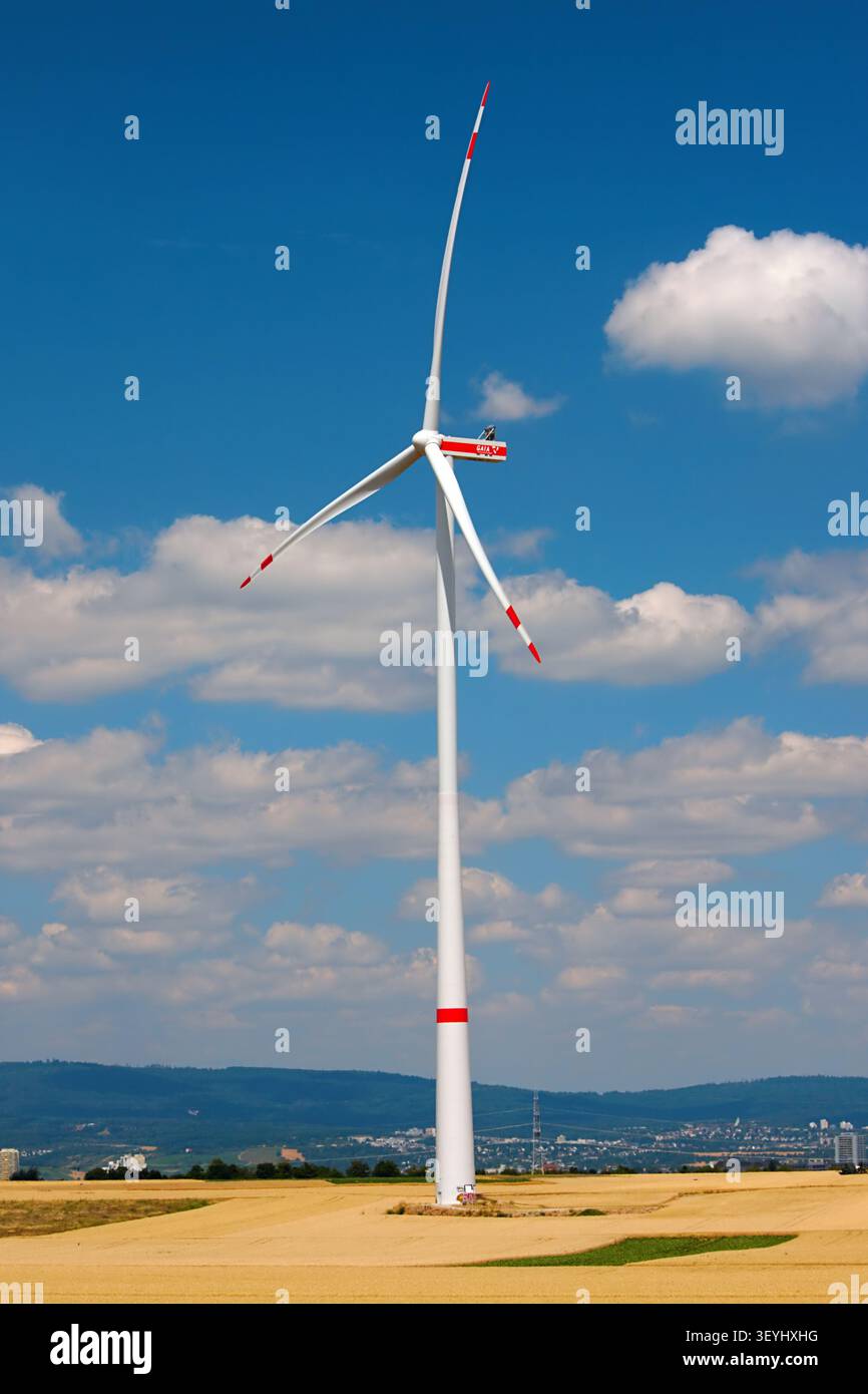 Mainz, Rheinland-Pfalz, Deutschland - 2. Juli 2026: Moderne Windkraftanlage über goldenen Feldern unter blauem Himmel mit verstreuten Wolken Stockfoto