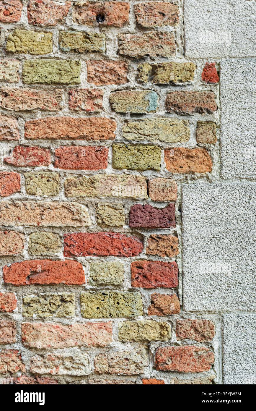 Alte Mauer aus gemischtem Ziegelstein und Stein mit einem hellen Putzrand, die mehrschichtige Mauerwerk-Textur und historische Oberflächendetails zeigt. Stockfoto