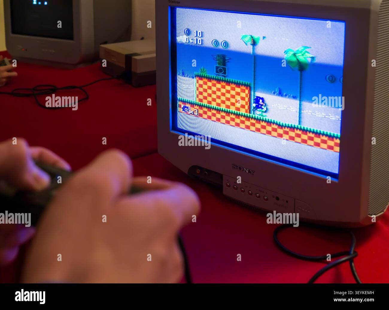 Besucher, der das klassische Videospiel Sonic the Igel auf einem CRT-Fernseher bei einer Retro-Gaming-Ausstellung spielt. Stockfoto