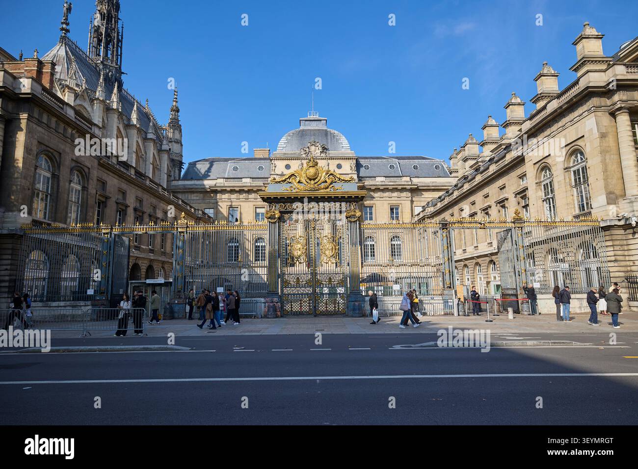 Vorderansicht des Palais de Justice und der Sainte Chapelle in Paris, Frankreich, mit verzierten goldenen Toren und klarem blauen Himmel. Paris, Frankreich - 11. Oktober 2025. Stockfoto