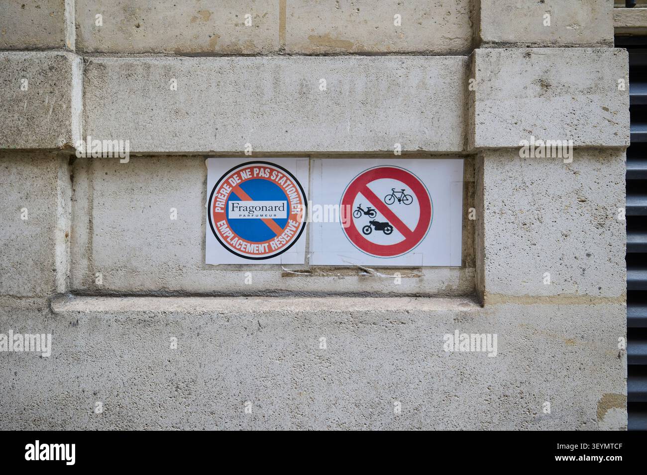 Es gibt keine Parkplätze und es gibt Schilder für den privaten Bereich an der Steinmauer. Paris, Frankreich - 13. Oktober 2025. Stockfoto