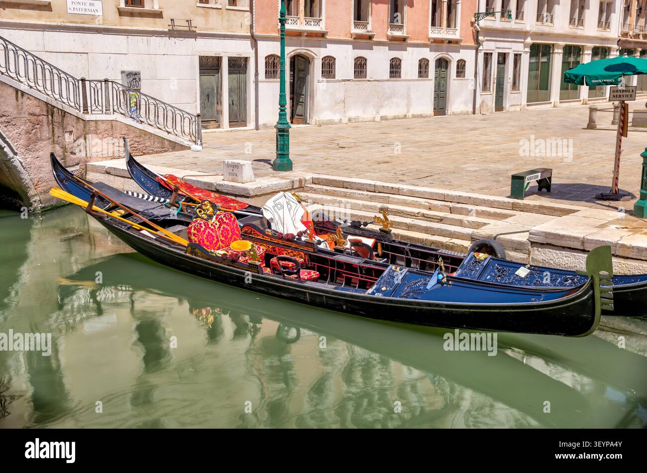 Traditionelle venezianische Gondel, die neben einem ruhigen Kanal im historischen Zentrum von Venedig, Italien, festgemacht ist. Stockfoto