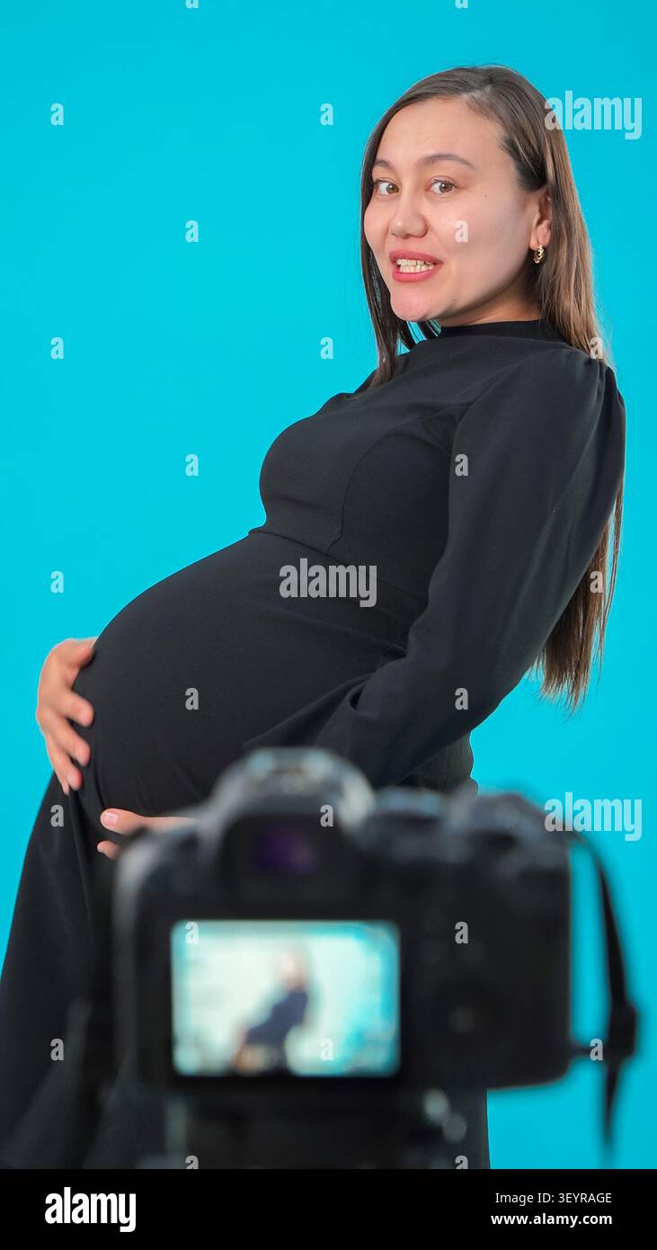 Schwangere Frau posiert hinter Videokamera in einem professionellen Foto s... Stockfoto