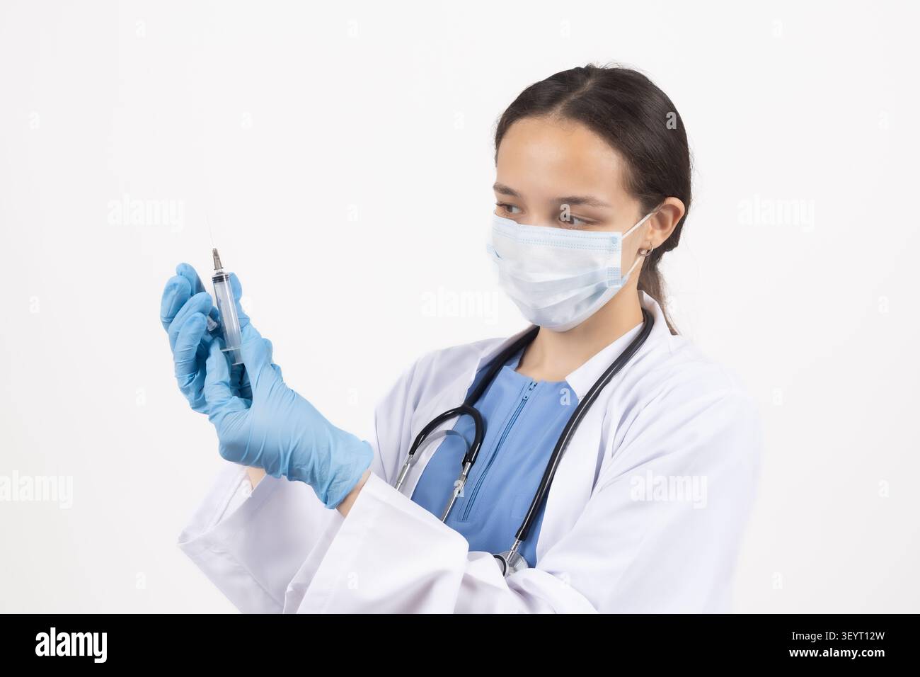 Mediziner halten die Spritze, die sie ansieht Stockfoto